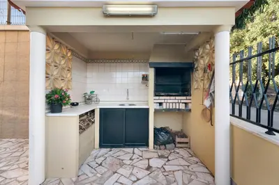a living room with a table and a blue chair and a kitchen at Casa da Várzea in Albufeira
