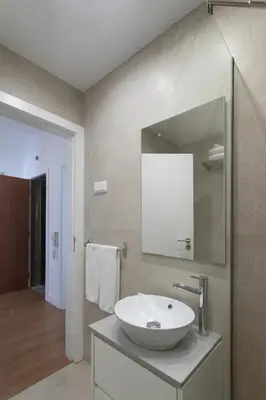 a bathroom with a white sink and a mirror at AL - Apartamentos Vista Mar in Quarteira