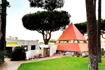 a house with a red pyramid roof on top of a yard at Villa With BBQ and Pool in Vilamoura in Quarteira