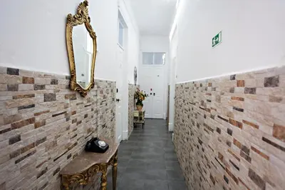 a hallway with a mirror on a brick wall at Baixa Terrace Hostel in Faro