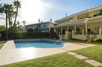 a swimming pool in front of a house at Mar e Golfe - Pool with golf view by HD in Vilamoura