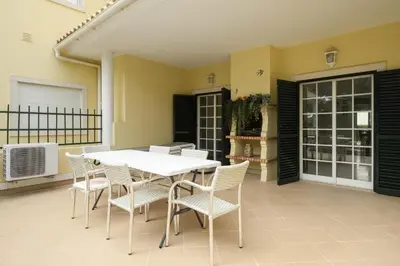 a white table and chairs on a patio at Mar e Golfe - Pool with golf view by HD in Vilamoura