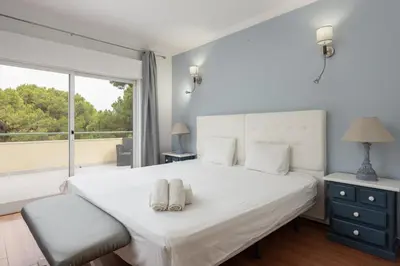 a bedroom with a white bed and a large window at Vila Popa - Golf Front with Games Room by HD in Vilamoura