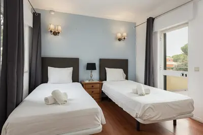two twin beds in a room with a window at Vila Popa - Golf Front with Games Room by HD in Vilamoura