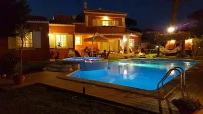 a swimming pool in front of a house at night at Vila Luz in Vilamoura