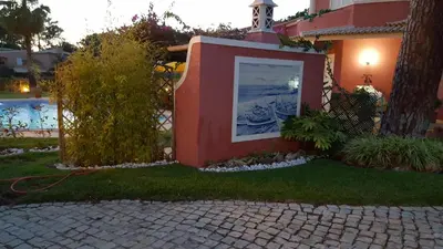 a picture on the side of a house next to a yard at Vila Luz in Vilamoura