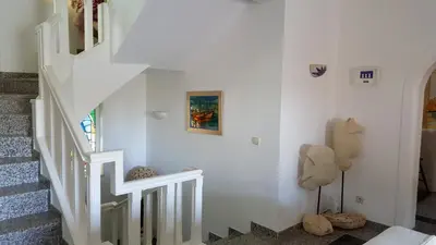 a white staircase in a home with white walls at Vila Luz in Vilamoura
