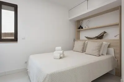 a white bedroom with a large white bed at Marina Praia - Marina view by HD in Vilamoura