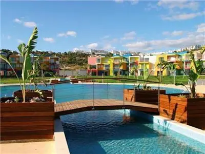 a swimming pool with a bridge and some buildings at Charming Orada 2-Bedroom Albufeira Duplex Apartment with Shared Pool sleeps 6 in Albufeira