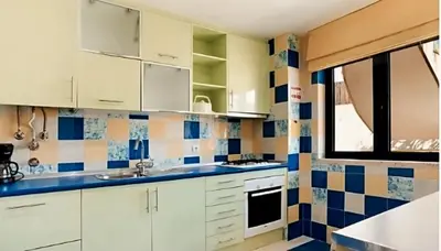 a kitchen with white cabinets and blue and white tiles at Charming Orada 2-Bedroom Albufeira Duplex Apartment with Shared Pool sleeps 6 in Albufeira