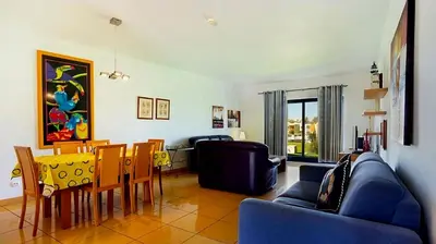a living room with a couch and a table and chairs at Charming Orada 2-Bedroom Albufeira Duplex Apartment with Shared Pool sleeps 6 in Albufeira