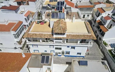 a bathroom with a toilet and a door with a house holidays sign at #352 Travessa do Mar Flats by Home Holidays in Albufeira