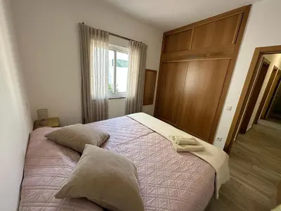a bedroom with a bed with two pillows on it at Casa do Outeiro - T2 Quarteira velha in Quarteira