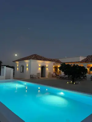 a swimming pool in front of a house at night at Casa Oliva do Sul in Almancil