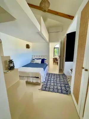 a bedroom with a bed and a blue rug at Casa Oliva do Sul in Almancil