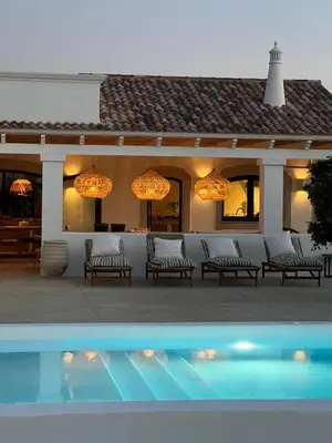 a patio with chairs and a pool in front of a house at Casa Oliva do Sul in Almancil