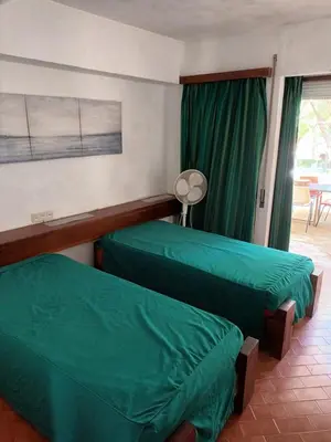 two beds in a room with green sheets at Studio Açoteias 410 in Albufeira