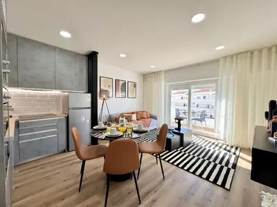 a kitchen and living room with a table and chairs at Albufeira Shine by Homing in Albufeira