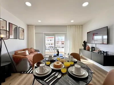 a living room with a table with food on it at Albufeira Shine by Homing in Albufeira