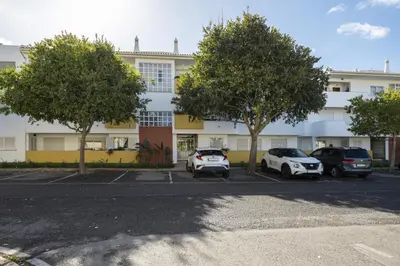 a building with cars parked in a parking lot at Vilamoura fresh by Hd in Vilamoura