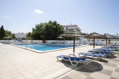 a large swimming pool with blue water in a building at Albufeira Olympics 1BR Apartment with Pool & Balcony, by Hopstays in Albufeira