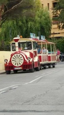 a red and white trolley car driving down a street at Villapinheiros in Vilamoura
