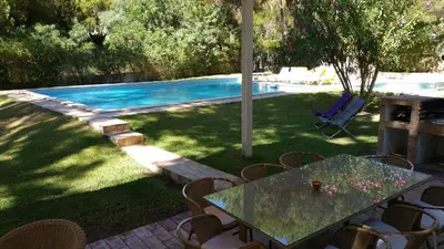 a table and chairs next to a swimming pool at Villapinheiros in Vilamoura