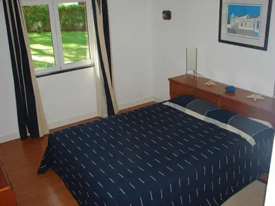 a bedroom with a blue bed and a window at Villapinheiros in Vilamoura