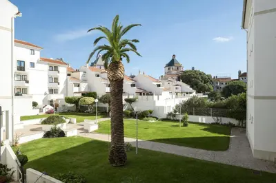 a palm tree in the courtyard of a building at Vilamoura central by HD in Vilamoura