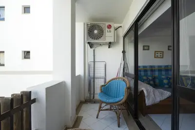 a room with a chair and a fan at Vilamoura central by HD in Vilamoura