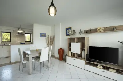 a kitchen and dining room with a table and a tv at Vilamoura central by HD in Vilamoura