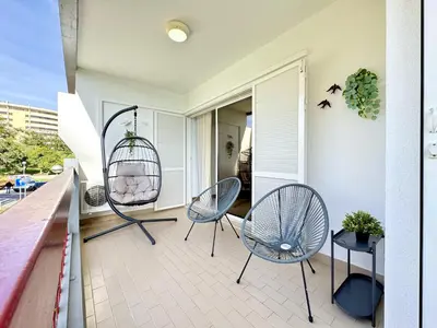 a balcony with two chairs and a bird cage at Vilamoura Marina Beach With Pool by Homing in Vilamoura