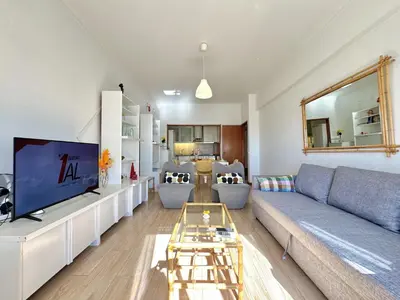 a living room with a couch and a tv at Quarteira Central 3 by Homing in Quarteira