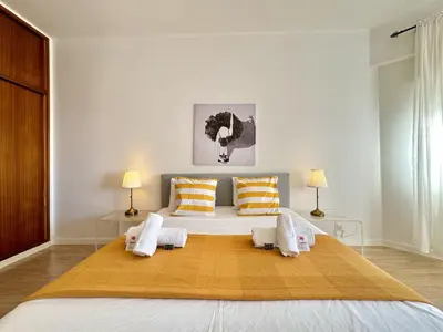a bedroom with a large bed with two pillows at Quarteira Central 3 by Homing in Quarteira