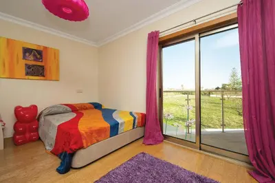 a bedroom with a bed and a large window at Villa Lando in Guia