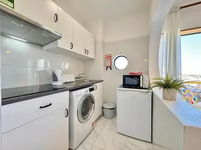 a kitchen with a washing machine and a microwave at Albufeira Vintage Apartment 2 With Pool by Homing in Albufeira