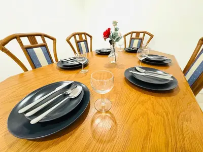 a wooden table with black plates and silverware on it at Blue Apartament in Albufeira