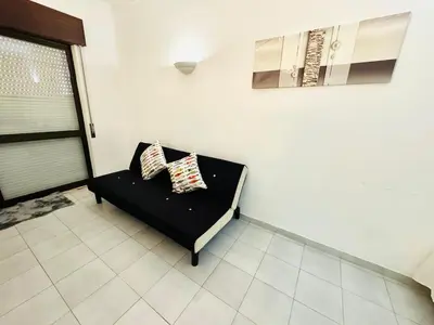 a black couch with two pillows in a room at Apartamento gourmet com quintal in Albufeira