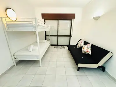 a room with a bunk bed and a couch at Apartamento gourmet com quintal in Albufeira