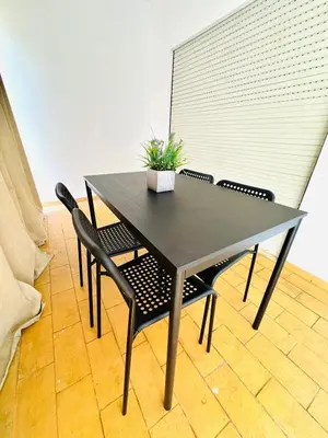 a black table and chairs with a potted plant on it at Apartamento gourmet com quintal in Albufeira
