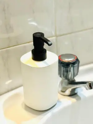 a soap dispenser sitting on top of a bathroom sink at Apartamento gourmet com quintal in Albufeira