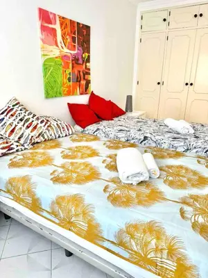 a large bed in a room with red pillows on it at Apartamento 5 estrelas praia da oura in Albufeira