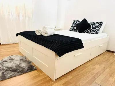 a white bed with black and white pillows on it at Apartment in Vilamoura Park in Quarteira