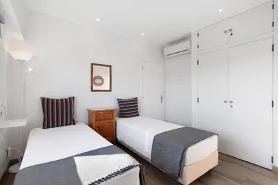 two beds in a room with white walls at Delmar in Quarteira