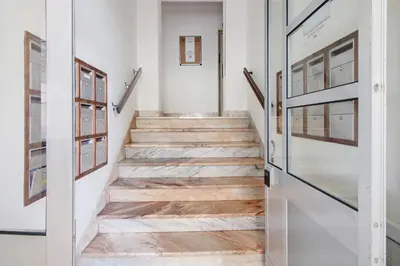 a hallway with wooden stairs with glass doors at Abertura Mar Zen in Quarteira