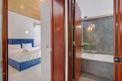 a bedroom with a bed and a bath tub next to a bed at Bento Box Villa Family Hub Fitness in Vilamoura