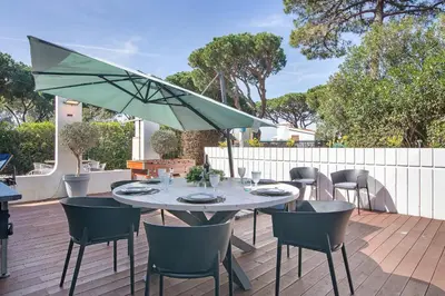 a table with chairs and an umbrella on a patio at Bento Box Villa Family Hub Fitness in Vilamoura