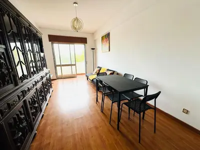 a living room with a table and chairs and a couch at Faro Family Apartment in Faro