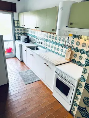 a kitchen with white cabinets and a stove top oven at Faro Family Apartment in Faro