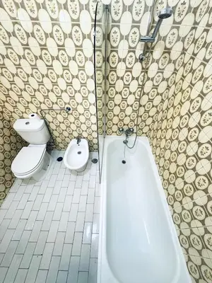 a bathroom with a toilet and a tub and a bidet at Faro Family Apartment in Faro